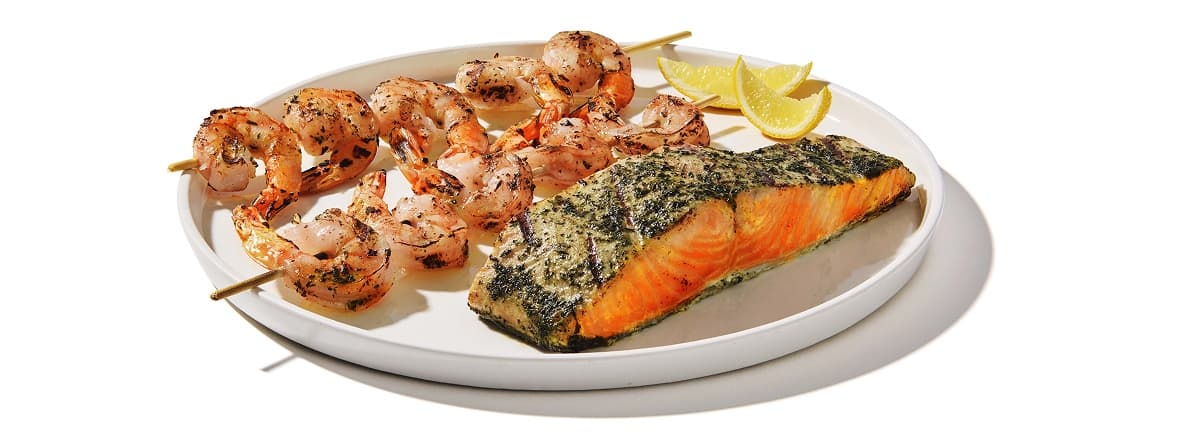 Shrimp kabobs and salmon filet on plate