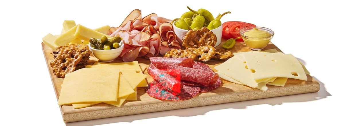 Deli meat and cheese on wooden board