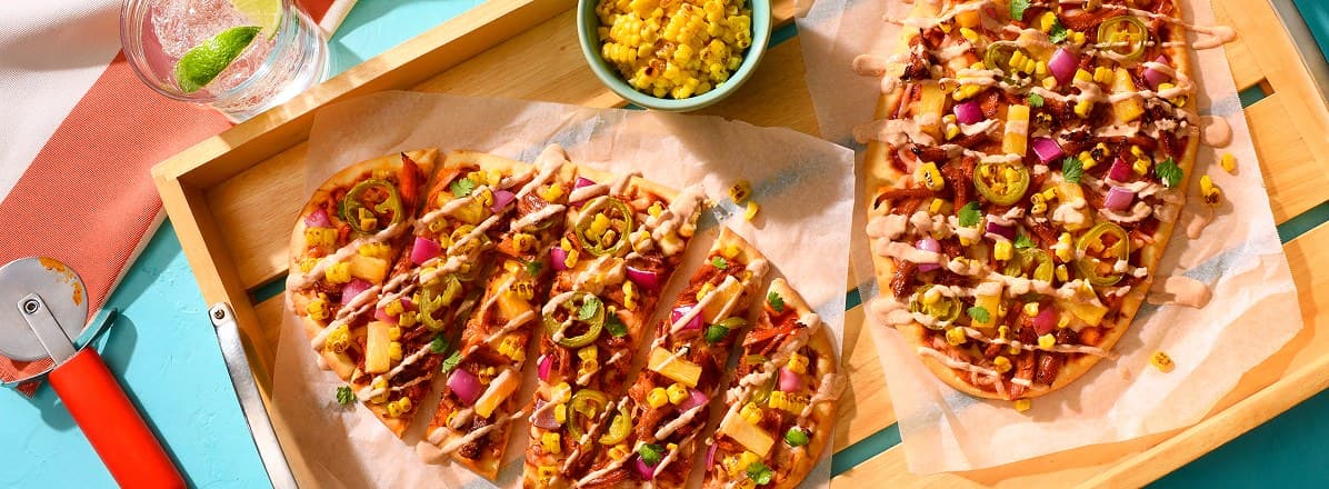 Elote-Style Al Pastor Pulled Pork Flatbread on bamboo serving tray
