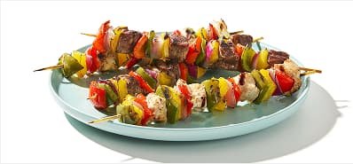 Variety of grilled kebabs, including chicken, beef and pork skewered with bell peppers and red onion.