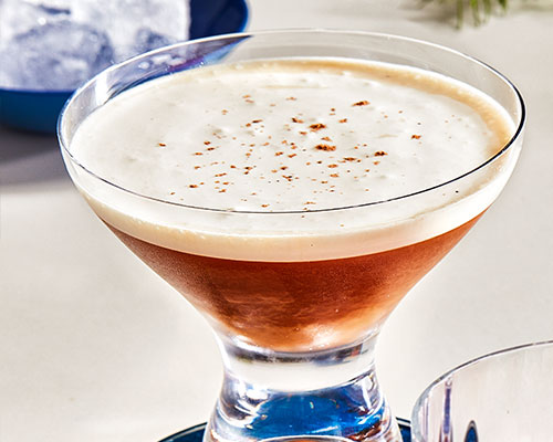 Short martini glass filled with coffee-based zero-spirit cocktail, topped with Fresh nutmeg