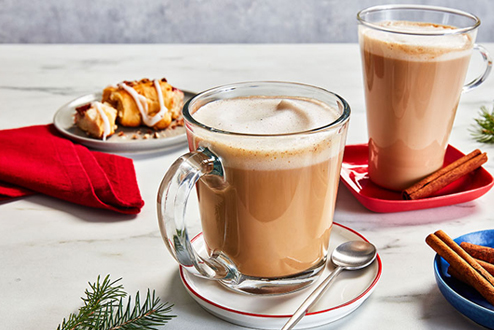 Two gingerbread almond lattes in clear mugs on a holiday table.