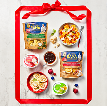 Flat lay on marble with Giovanni Rana Fresh Pastas, Compliments sauces and a red ribbon around it all