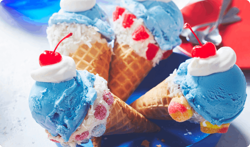 Four chocolat and candy-dipped waffle cones with bubblegum ice cream and a maraschino cherry on top