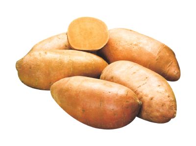 Grouping of sweet potatoes on a white counter with one of them cut in half.