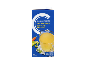 Blue tetra Pak of Compliments Chicken Broth with a measuring cup image on the front full of broth.