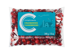 Clear plastic bag of Compliments fresh cranberries with a blue illustration of a farmhouse.