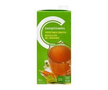 Green tetra pack of Compliments Vegetable broth showing a measuring cup full of broth.