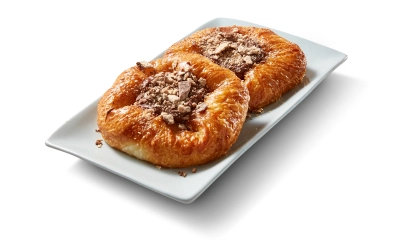 Butter Danish topped with kit kat pieces on a white plate.