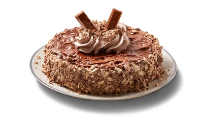 Chocolate single layer cake covered in Kit Kat crumbs on the side, topped with chocolate icing, and pieces of the candy bar.