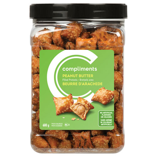 Clear plastic jar featuring Compliments peanut butter filled pretzels with a green label on the front.