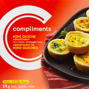 Orange box with Compliments logo and image of black serving platter with min quiche tarts printed on front