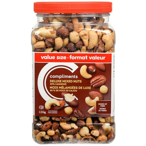 Tin with a brown label of Compliments Deluxe 40% Roasted Cashews Mixed Nuts depicting various nuts on the label.