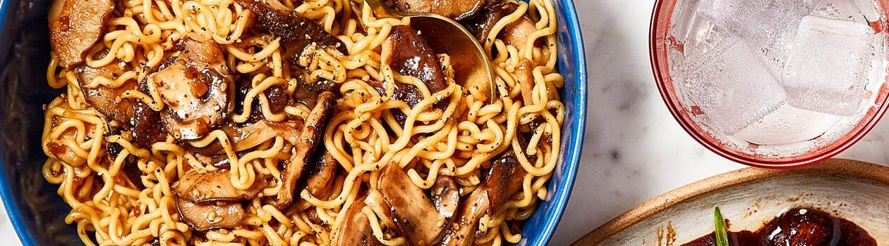 Blue bowl of ramen noodles with mushrooms.