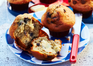 Strawberry, blueberry and chocolate chip muffins on a white and blue-patterned plate.