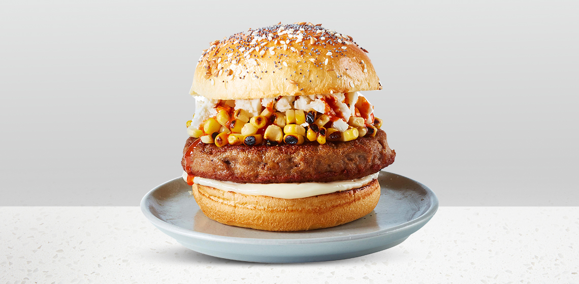 Mexican Street Style Corn Burger: multiseed bun, turkey burger patty, grilled corn, hot sauce, mayo, and cheese.