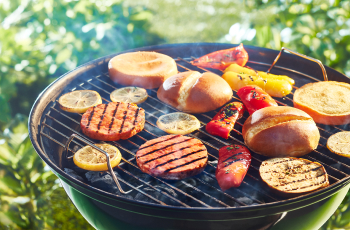 open round grill with salmon burgers and burger buns