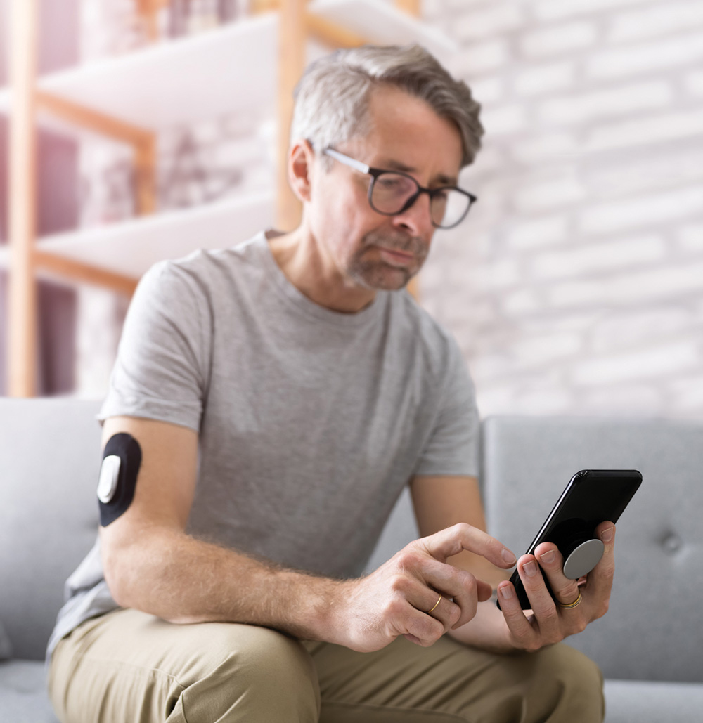 man with blood glucose meter and phone