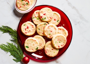 Round red platter with icebox shortbread cookies laid out, and a cup of tea to the side