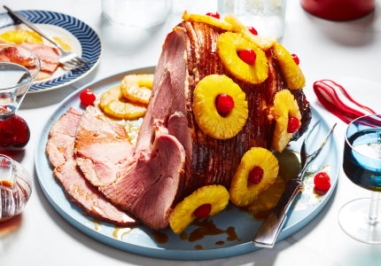 Light blue serving platter with Panache Spiral Sliced Ham studded with pineapple rings and red cherries.